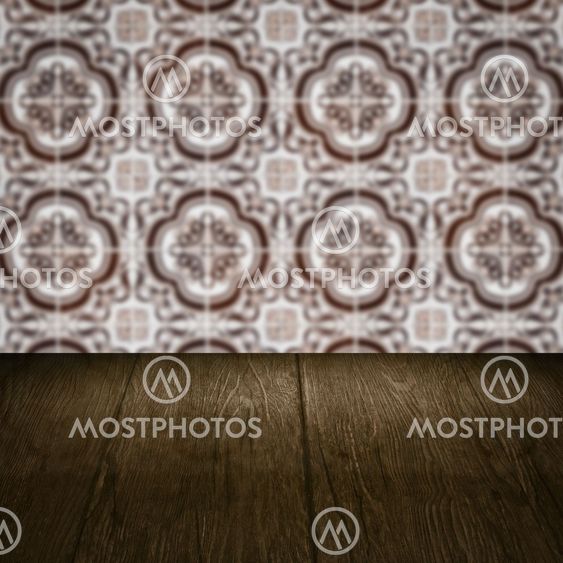 Wood table top and blur vintage ceramic tile pattern wall