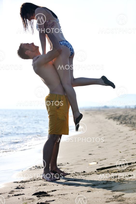happy young couple have fun on beach