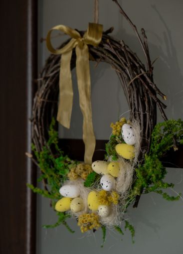 Handmade Easter wreath festive yellow egg decorations on...