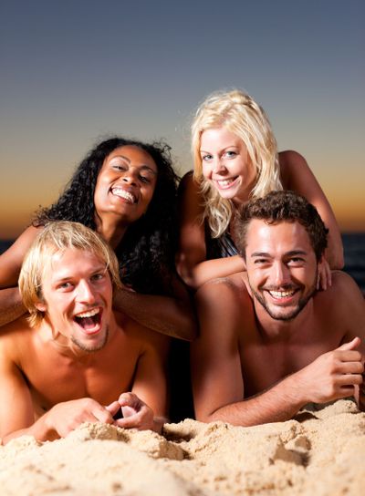 Four friends at the beach with sunset