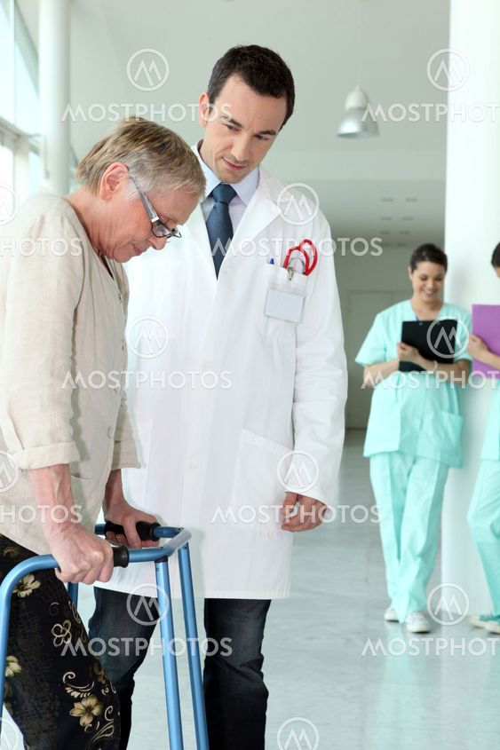 Elderly woman using a walking frame in a hospital
