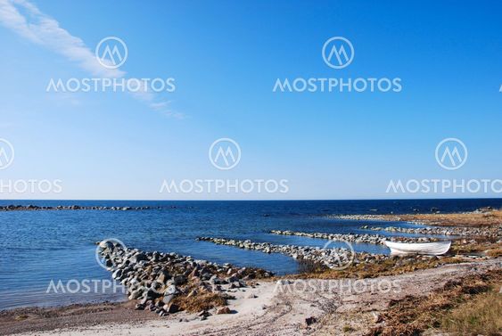 Rocky coast with a single moored rowing boat.