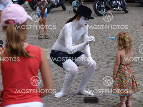 Street actor and young girl (tourist) on Old Market Place in Kazimierz Dolny, Poland