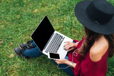 Top view of a young woman in hat using laptop