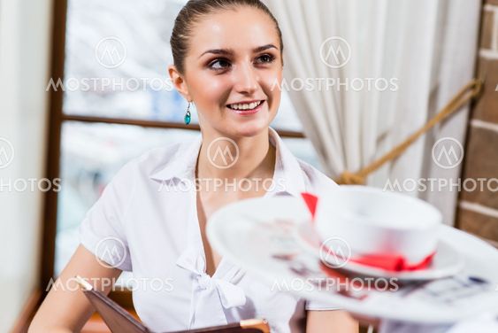 waiter brings a dish for a nice woman