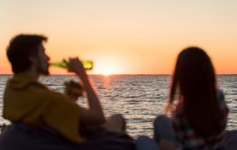 friends admiring sunset while having beer