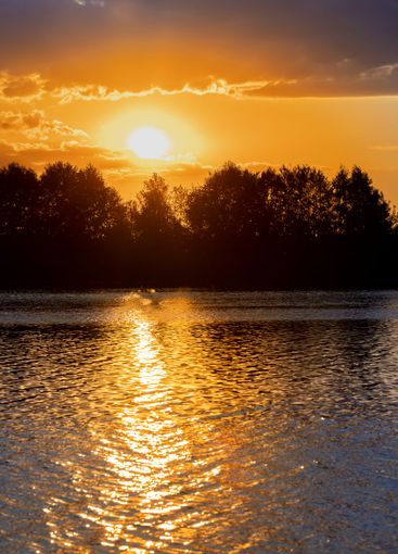 the lake with orange water in the summer at sunset