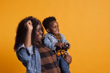 Loving mother acting silly and dancing with her infant son