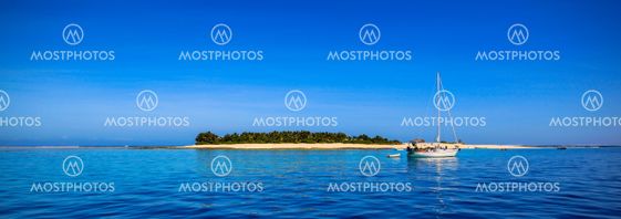 Boat and beautiful Fiji atoll island with white beach
