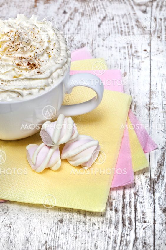 hot chocolate with marshmallows and cream on wooden background