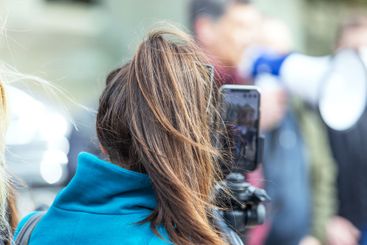 Mobile journalist filming protest, rally or media event