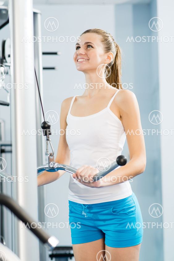 young woman doing body-building in the Gym