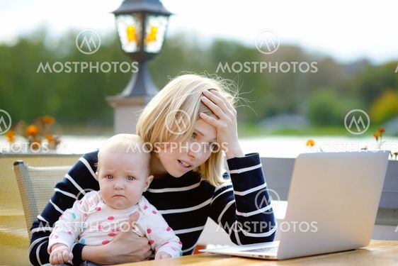Tired young mother working oh her laptop