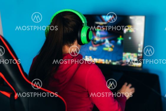 The gamer sits on a gaming chair and plays computer...