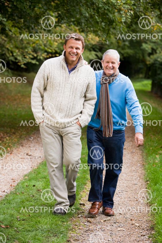 Adult father and son walking along path