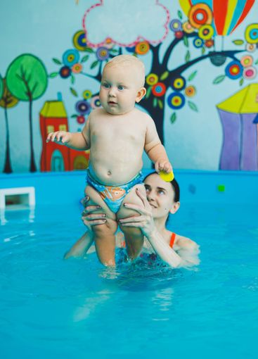 Baby boy swimming in the pool. Swimming pool for babies...