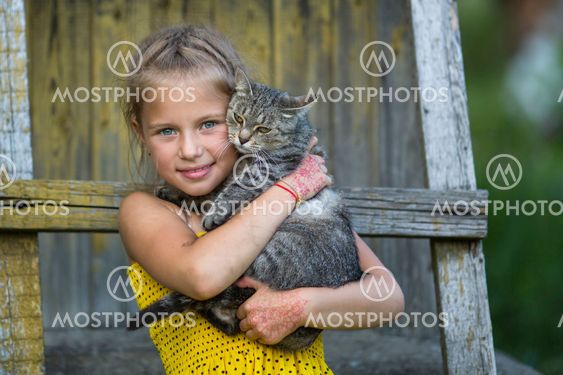 Little girl playing with a cat.