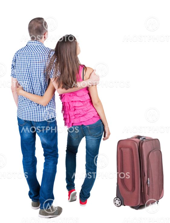 Back view of young couple traveling with suitcas .