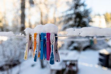 snow-covered clothespins close up in backyard