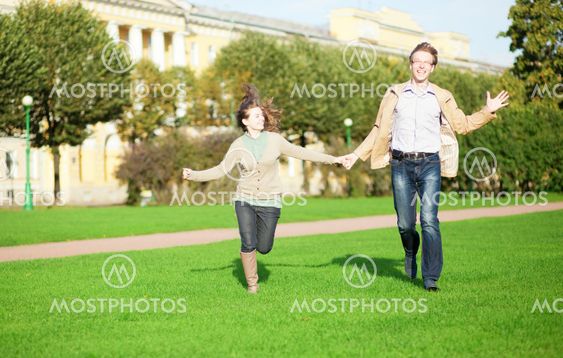 Happy couple running in park