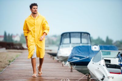 Young handsome sailor man walking at the sea pier