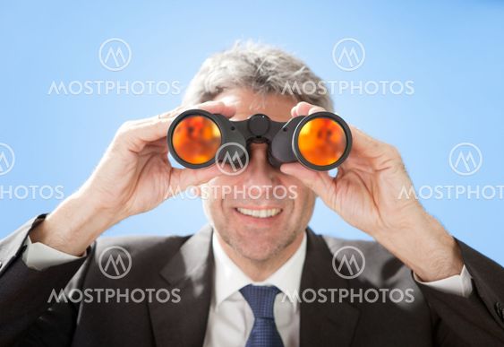 Senior businessman looking through binoculars