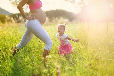 Pregnant mother with her daughter exercising