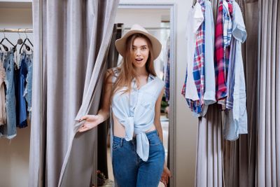 Happy young woman standing in fitting room