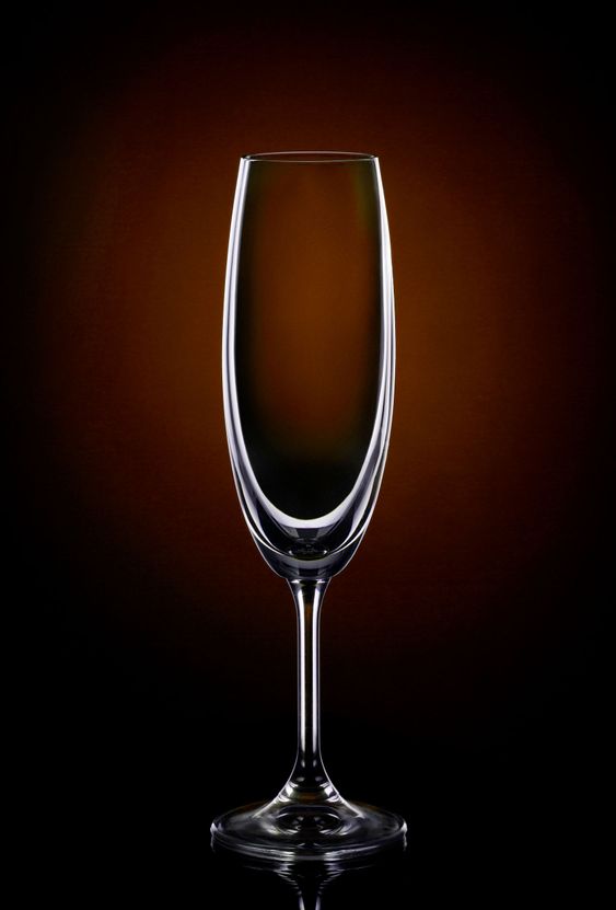 Empty wine glass on dark red