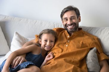 Portrait of father hugging little daughter sit together...