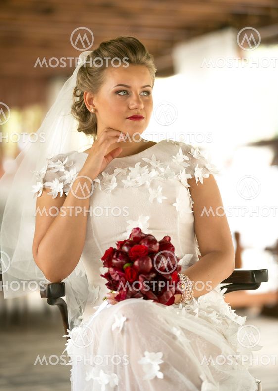 portrait of beautiful elegant bride with red bouquet...