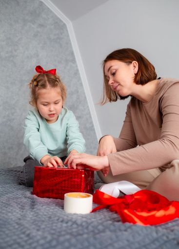 Mid shot of mother and daughter together packing a...