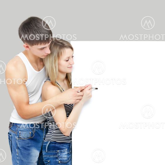 Young beautiful couple draws on placard