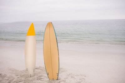 Two surfboard standing in sand
