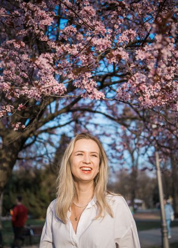 Woman with cherry flowers surrounded by blossoming trees...