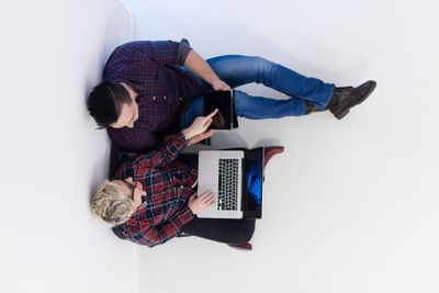 top view of  couple working on laptop computer at startup...