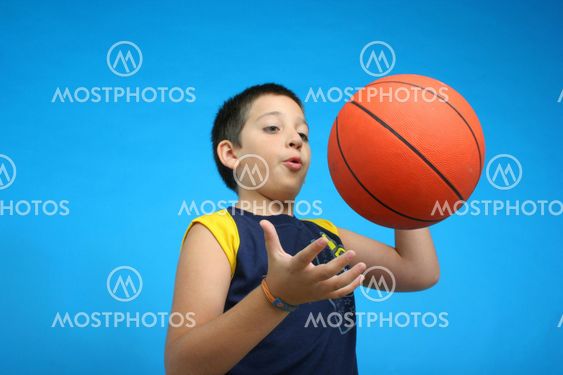 Dreng spiller basketball. blå baggrund