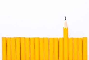 Yellow pencils arranged with one pencil standing out...