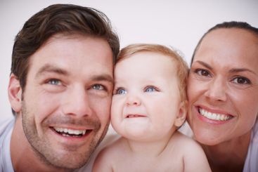 Portrait, parents and smile with baby in home for relax,...