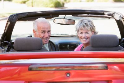 Couple in convertible car smiling