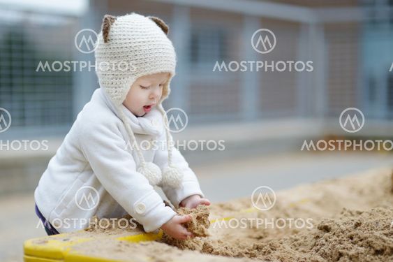 Adorable toddler girl playing in a sandbox