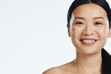 Face, asian woman and laughing for beauty in studio,...