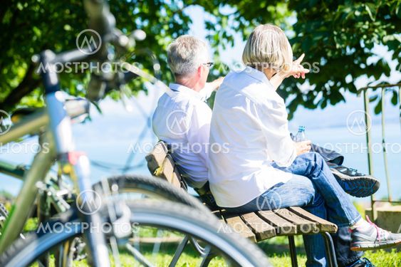 Senior woman and man at rest on bike trip