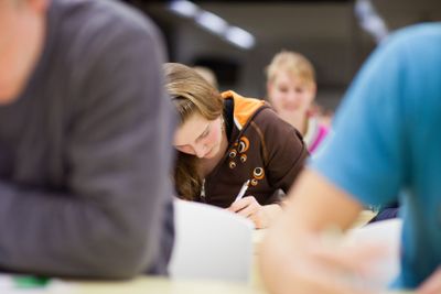 pretty, female college student sitting in a classroom...