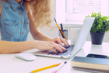 Beautiful caucasian woman sitting and working on laptop