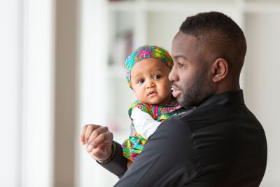 Young african american father holding with her baby girl