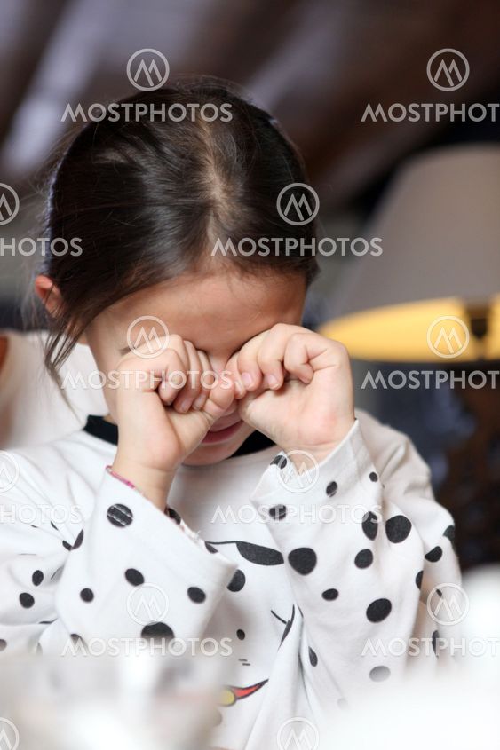 Little girl rubbing her eyes