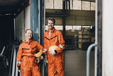 Portrait of confident male and female workers in uniform...