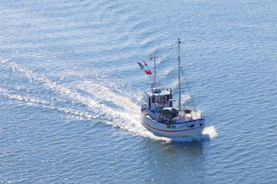 Small fishing boat on the blue sea heading back after...