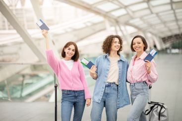 Three friends celebrate their travel plans at a modern...